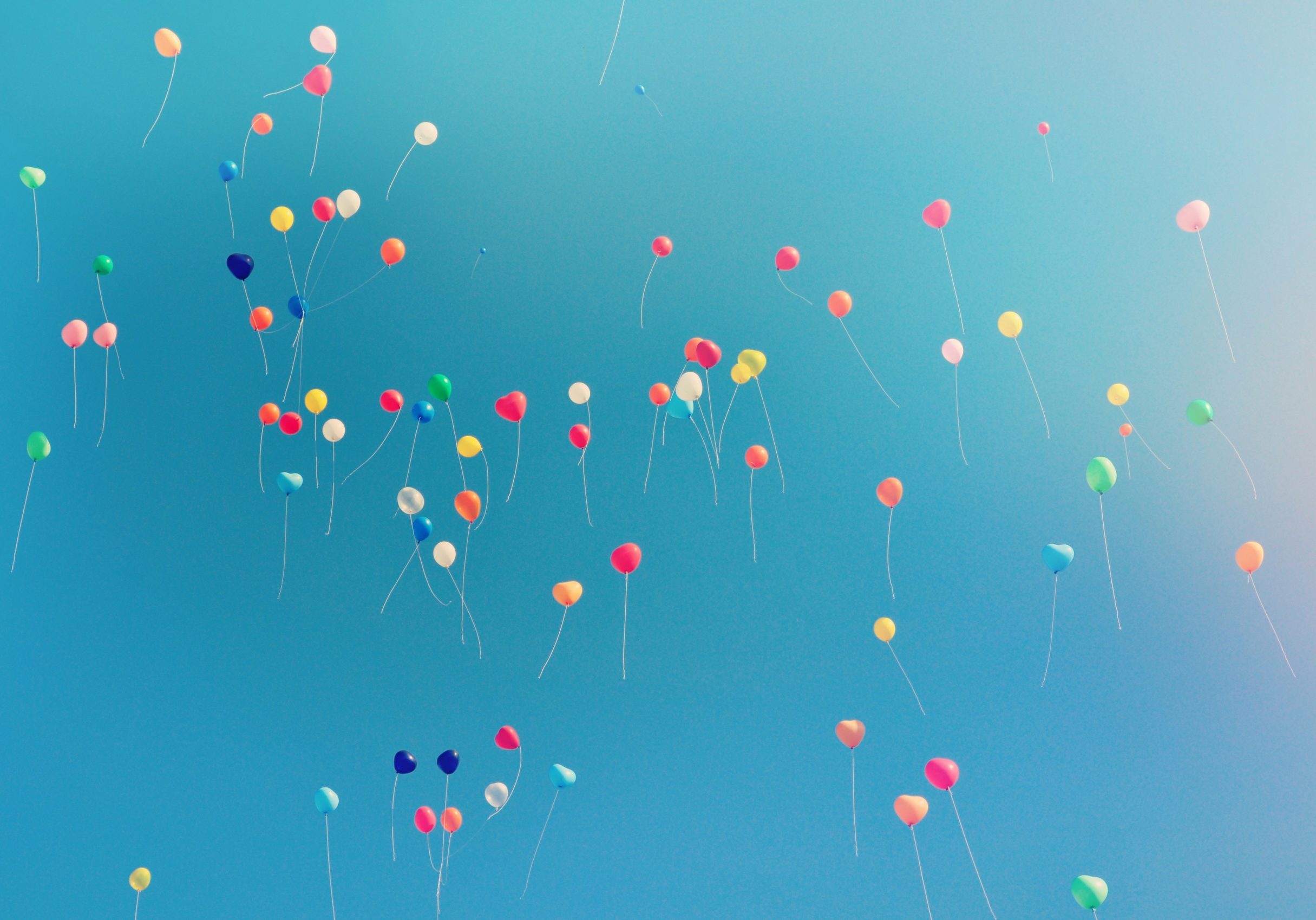 Viele bunte Luftballons in einem blauen Himmel